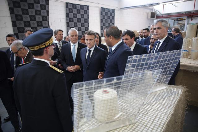 France's President Emmanuel Macron (C) visits the future site of the Occitanie Géotex plant, which will manufacture geotextiles for construction, roads, and agriculture using plant-based hemp fibers and wool produced in the region, in Laroque-d'Olmes, south-western France, on April 27, 2026. Emmanuel Macron will travel to south western France's Ariège department on April 27, 2026, a trip focused on reindustrialization and health, before a two-day visit to the microstate of Andorra of which his is also Co-Prince, where the sensitive issue of abortion will be discussed. (Photo by Valentine CHAPUIS / POOL / AFP)