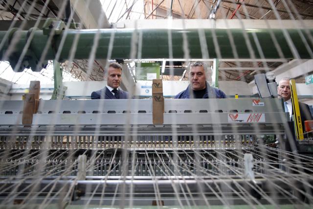 France's President Emmanuel Macron listens to explanations as he visits the future site of the Occitanie Géotex plant, which will manufacture geotextiles for construction, roads, and agriculture using plant-based hemp fibers and wool produced in the region, in Laroque-d'Olmes, south-western France, on April 27, 2026. Emmanuel Macron will travel to south western France's Ariège department on April 27, 2026, a trip focused on reindustrialization and health, before a two-day visit to the microstate of Andorra of which his is also Co-Prince, where the sensitive issue of abortion will be discussed. (Photo by Valentine CHAPUIS / POOL / AFP)