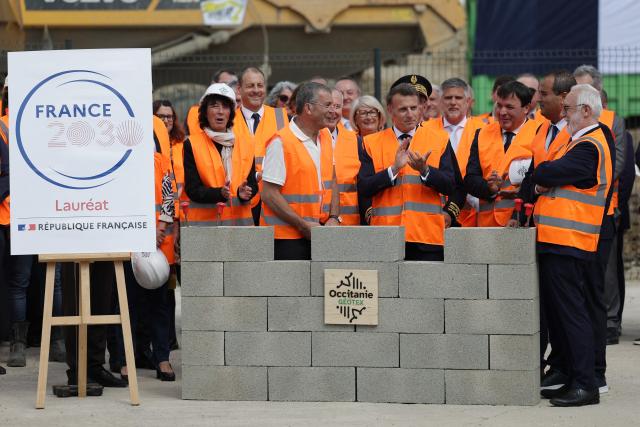 France's President Emmanuel Macron (C) applauds next to founder and Director Victor Lamego (2ndR) as they lay on the first stone at the future site of the Occitanie Géotex plant, which will manufacture geotextiles for construction, roads, and agriculture using plant-based hemp fibers and wool produced in the region, in Laroque-d'Olmes, south-western France, on April 27, 2026. Emmanuel Macron will travel to south western France's Ariège department on April 27, 2026, a trip focused on reindustrialization and health, before a two-day visit to the microstate of Andorra of which his is also Co-Prince, where the sensitive issue of abortion will be discussed. (Photo by Valentine CHAPUIS / POOL / AFP)