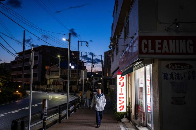 A man walks past a dry cleaner in Kawasaki, Kanagawa prefecture on April 27, 2026. (Photo by Yuichi YAMAZAKI / AFP)