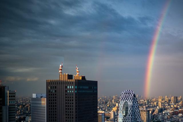 A general view shows the city skyline and a rainbow from the Tokyo Metropolitan Government Building observation deck in the Shinjuku district of central Tokyo on April 27, 2026. (Photo by Philip FONG / AFP)