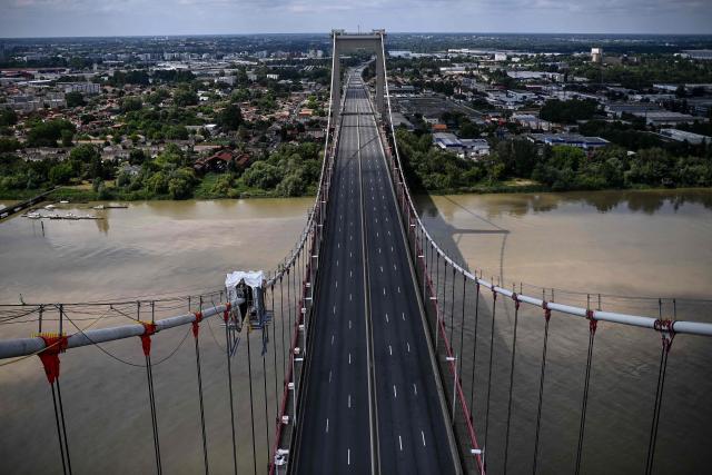 This picture shows the trafficless deck of the closed Pont d'Aquitaine (Aquitaine bridge) during a maintenance operation in Bordeaux, south-western France, on April 26, 2026. Routine maintenance work is carried out regularly on the suspension Aquitaine bridge connecting Bordeaux and its northern suburb of Lormont over the Garonne river. Triggering the closure of Bordeaux's ring road, maintenance work on the second-longest suspension bridge in France is generally performed at night or during week-ends. (Photo by Christophe ARCHAMBAULT / AFP)