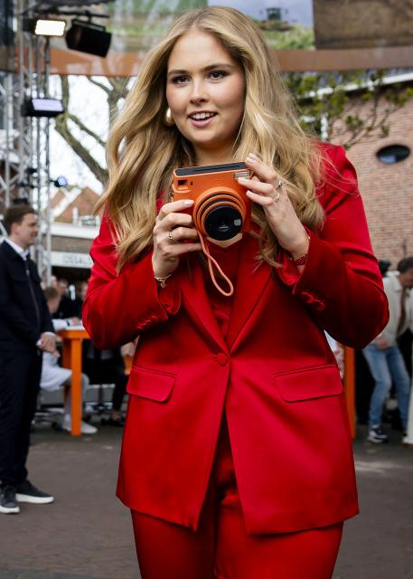Princess Amalia of the Netherlands holds an orange Fujifilm instax square polaroid camera during the King's Day celebrations, in Dokkum on April 27, 2026. King's day is a national holiday in the Kingdom of the Netherlands. Celebrated on 27 April the date marks the birth of King Willem-Alexander. (Photo by Sem van der Wal / various sources / AFP) / Netherlands OUT
