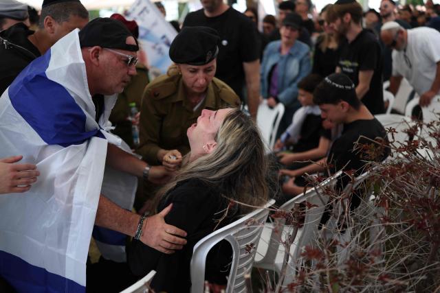 TOPSHOT - A relative and an Israeli soldier comfort the grieving mother of Sergeant Idan Fooks during his funeral in Petah Tikva on April 27, 2026. The Israeli military said on April 26 that a soldier was killed in southern Lebanon, where a ceasefire has been in place since mid-April. Sergeant Idan Fooks, 19, died "during combat" in south Lebanon, while "an officer and three additional soldiers were severely injured, along with a soldier who was moderately injured and a soldier who was lightly injured", the military said. (Photo by Ilia YEFIMOVICH / AFP) / 