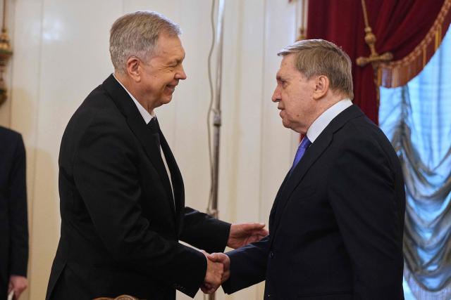 Admiral Igor Kostyukov, head of Russian military intelligence (GRU), and Kremlin foreign policy adviser Yuri Ushakov interact as they attend a meeting between Russian President and Iranian Foreign Minister at the Boris Yeltsin Presidential Library in Saint Petersburg on April 27, 2026. (Photo by Dmitry LOVETSKY / POOL / AFP)