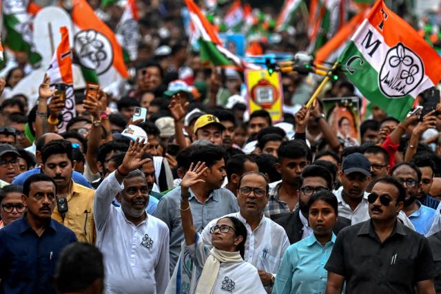 Chief Minister of West Bengal and Chairperson of All India Trinamool Congress, Mamata Banerjee (C), greets her supporters during a rally ahead of the second phase of the West Bengal Assembly Elections in Kolkata on April 27, 2026. (Photo by Dibyangshu SARKAR / AFP)