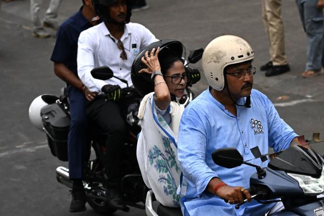 Chief Minister of West Bengal and Chairperson of All India Trinamool Congress, Mamata Banerjee (C), rides a scooty during a rally ahead of the second phase of the legislative assembly elections in Kolkata on April 27, 2026. (Photo by Dibyangshu SARKAR / AFP)