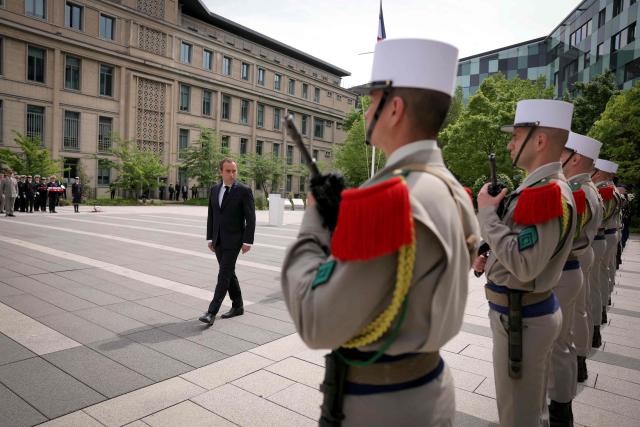 France's Prime Minister Sebastien Lecornu inspects the troops during a military parade to mark the naming of the Ministry of the Armed Forces’ main auditorium after Pierre Messmer, at The Invalides in Paris on April 27, 2026. (Photo by Thomas SAMSON / AFP)