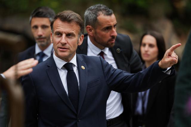 France's President and Co-Prince of Andorra Emmanuel Macron gestures as he arrives for a visit at the FEDA hydroelectric power plant in Andorra la Vella, in Andorra, on April 27, 2026. Emmanuel Macron will travel to south western France's Ariège department on April 27, 2026, a trip focused on reindustrialization and health, before a two-day visit to the microstate of Andorra of which his is also Co-Prince, where the sensitive issue of abortion will be discussed. (Photo by Valentine CHAPUIS / POOL / AFP)