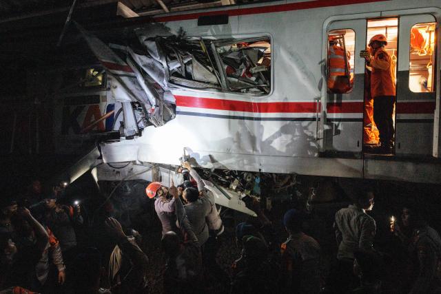 Rescuers work at the site where a passenger train locomotive pierced through the rear carriage of a commuter train at Bekasi Timur Station in Bekasi, West Java, on April 28, 2026. Two trains collided outside the Indonesian capital Jakarta late on April 27, 2026, the state-owned rail company KAI said, killing at least two people and prompting a mass evacuation effort. (Photo by Yasuyoshi Chiba / AFP)