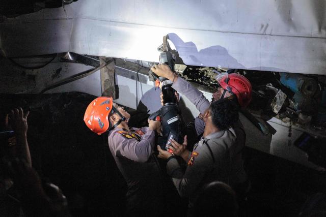 Rescuers work at the site where a passenger train locomotive pierced through the rear carriage of a commuter train at Bekasi Timur Station in Bekasi, West Java, on April 28, 2026. Two trains collided outside the Indonesian capital Jakarta late on April 27, 2026, the state-owned rail company KAI said, killing at least two people and prompting a mass evacuation effort. (Photo by YASUYOSHI CHIBA / AFP)