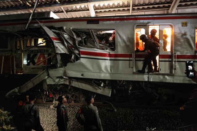 Rescuers work at the site where a passenger train locomotive pierced through the rear carriage of a commuter train at Bekasi Timur Station in Bekasi, West Java, on April 28, 2026. Two trains collided outside the Indonesian capital Jakarta late on April 27, 2026, the state-owned rail company KAI said, killing at least two people and prompting a mass evacuation effort. (Photo by Yasuyoshi Chiba / AFP)