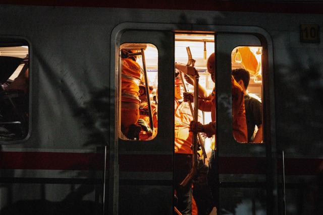 Rescuers work at the site where a passenger train locomotive pierced through the rear carriage of a commuter train at Bekasi Timur Station in Bekasi, West Java, on April 28, 2026. Two trains collided outside the Indonesian capital Jakarta late on April 27, 2026, the state-owned rail company KAI said, killing at least two people and prompting a mass evacuation effort. (Photo by Yasuyoshi Chiba / AFP)