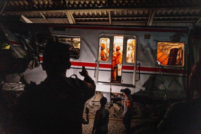 Rescuers work at the site where a passenger train locomotive pierced through the rear carriage of a commuter train at Bekasi Timur Station in Bekasi, West Java, on April 28, 2026. Two trains collided outside the Indonesian capital Jakarta late on April 27, 2026, the state-owned rail company KAI said, killing at least two people and prompting a mass evacuation effort. (Photo by Yasuyoshi Chiba / AFP)