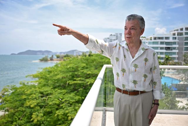 Colombia's former president (2010-2018) Juan Manuel Santos points at a ship during an interview with AFP in the sidelines of the First Conference Transitioning away from Fossil Fuels at Port Beach in Santa Marta, on April 27, 2026. (Photo by Raul ARBOLEDA / AFP)