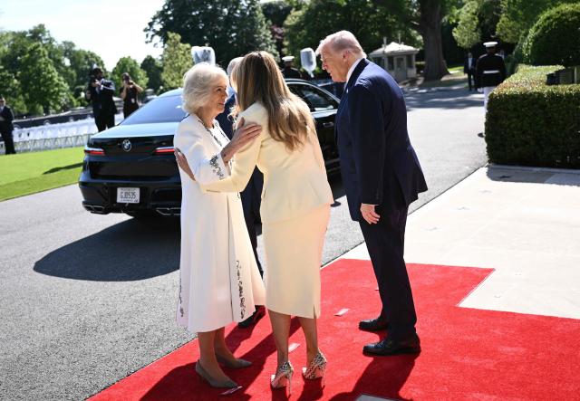 US President Donald Trump (R) and First Lady Melania Trump (C/R) greet Britain's Queen Camilla (L) and Britain's King Charles III (hidden) upon arrival at the South Portico of the White House in Washington, DC, on April 27, 2026. (Photo by Brendan SMIALOWSKI / AFP)