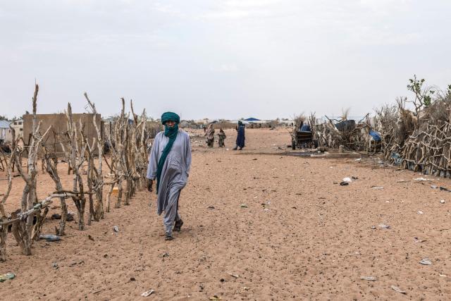 A refugee walks across the tracks at M’berra refugee camp, which hosts 120,000 refugees fleeing violence and instability in Mali, in the Hodh Ech Chargui region of Mauritania, on April 27, 2026. Thousands of people have died in attacks in Mali since the jihadist turmoil erupted and tens of thousands of Malians have sought refuge in neighbouring countries, including Mauritania, in recent years. (Photo by PATRICK MEINHARDT / AFP)