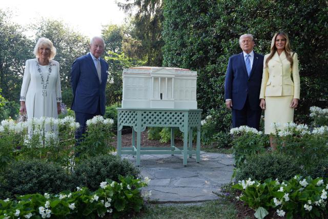 US President Donald Trump, First Lady Melania Trump, Britain's King Charles III and Britain's Queen Camilla pose by a model of Trump's proposed ballroom as they tour the White House beehive on the South Lawn of the White House in Washington, DC, on April 27, 2026. (Photo by Alex Brandon / POOL / AFP)