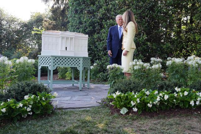 US President Donald Trump and First Lady Melania Trump speak by a model of Trump's proposed ballroom as they tour the White House beehive with Britain's monarch on the South Lawn of the White House in Washington, DC, on April 27, 2026. (Photo by Alex Brandon / POOL / AFP)