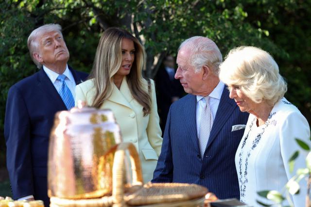 US President Donald Trump, First Lady Melania Trump, Britain's King Charles III and Britain's Queen Camilla look at a display as they tour the White House beehive on the South Lawn of the White House in Washington, DC, on April 27, 2026. (Photo by Suzanne Plunkett / POOL / AFP)