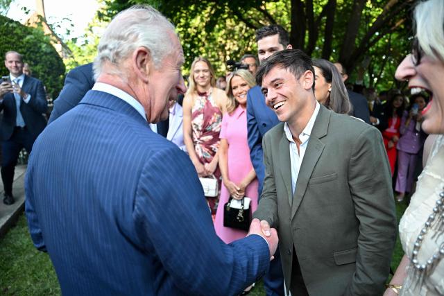 Britain's King Charles III chats with English retired diver Tom Daley (R) and other guests during a garden party at the British Ambassador's Residence in Washington, DC, on April 27, 2026. (Photo by Samir HUSSEIN / POOL / AFP)