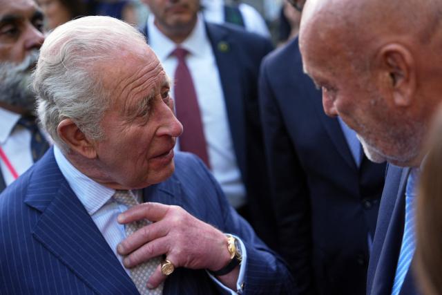 Britain's King Charles III chats with an attendee of a garden party at the British Ambassador's Residence in Washington, DC, on April 27, 2026. (Photo by Julia Demaree Nikhinson / POOL / AFP)