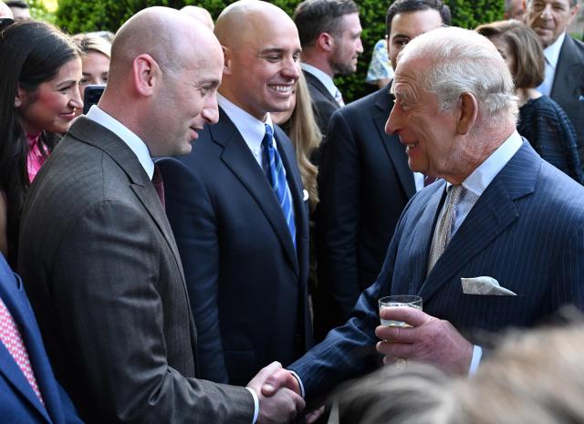Britain's King Charles III shakes hads with the White House Deputy Chief of Staff for Policy Stephen Miller during a garden party at the British Ambassador's Residence in Washington, DC, on April 27, 2026. (Photo by Roberto Schmidt / POOL / AFP)