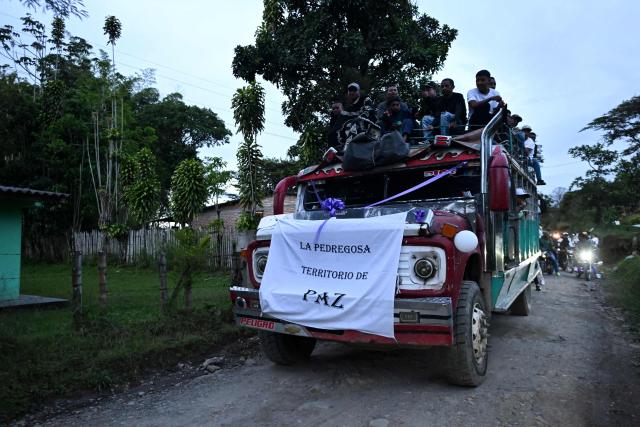 A sign that reads "La Pedregosa, a land of peace" is displayed on a chiva bus during a funeral procession following a bomb attack in Cajibio, Cauca department, Colombia, on April 27, 2026. The death toll in a Colombian highway bombing blamed on cocaine-trafficking rebels rose to 21, the government said on April 27, after the worst attack on civilians in decades, coming ahead of key elections. (Photo by JOAQUIN SARMIENTO / AFP)