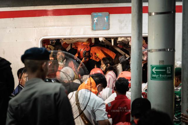 Rescuers work to save five survivors trapped inside a carriage after a passenger train locomotive pierced through the rear car of a commuter train at Bekasi Timur station in Bekasi, West Java on April 28, 2026. (Photo by Yasuyoshi Chiba / AFP)