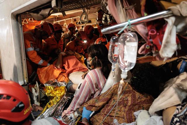 Rescuers work to save five survivors trapped inside a carriage after a passenger train locomotive pierced through the rear car of a commuter train at Bekasi Timur station in Bekasi, West Java on April 28, 2026. (Photo by Yasuyoshi Chiba / AFP)