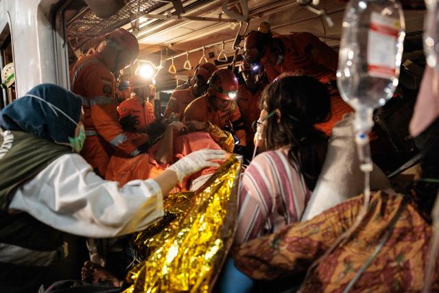 Rescuers work to save five survivors trapped inside a carriage after a passenger train locomotive pierced through the rear car of a commuter train at Bekasi Timur station in Bekasi, West Java on April 28, 2026. (Photo by Yasuyoshi Chiba / AFP)