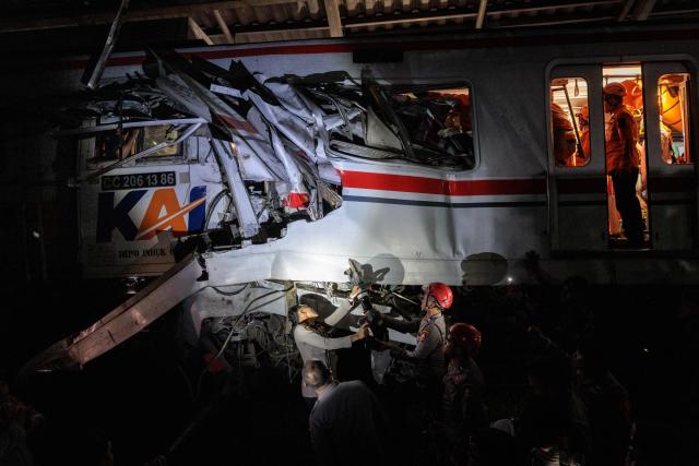Rescuers work to save five survivors trapped inside a carriage after a passenger train locomotive pierced through the rear car of a commuter train at Bekasi Timur station in Bekasi, West Java on April 28, 2026. (Photo by Yasuyoshi Chiba / AFP)