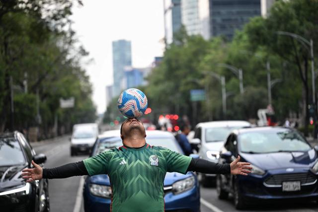 Former Mexican footballer Diego Ivan Carmona, 40, performs a freestyle routine with a ball on a traffic light in Mexico City on April 27, 2026. Mexico will co-host the biggest World Cup in history along with the United States and Canada from June 11 to July 19, 2026. (Photo by Yuri CORTEZ / AFP)