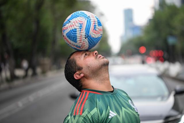 Former Mexican footballer Diego Ivan Carmona, 40, performs a freestyle routine with a ball on a traffic light in Mexico City on April 27, 2026. Mexico will co-host the biggest World Cup in history along with the United States and Canada from June 11 to July 19, 2026. (Photo by Yuri CORTEZ / AFP)