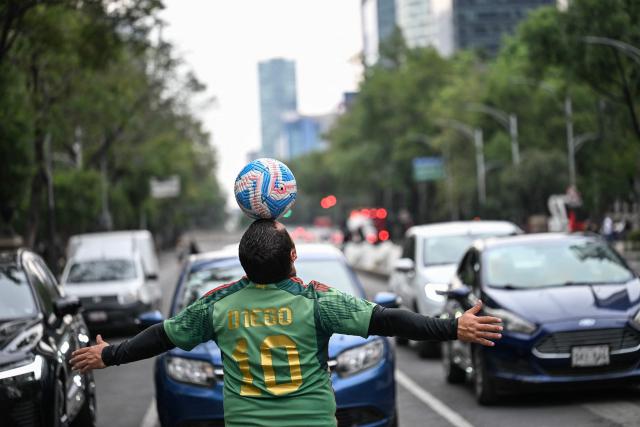 Former Mexican footballer Diego Ivan Carmona, 40, performs a freestyle routine with a ball on a traffic light in Mexico City on April 27, 2026. Mexico will co-host the biggest World Cup in history along with the United States and Canada from June 11 to July 19, 2026. (Photo by Yuri CORTEZ / AFP)