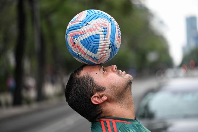Former Mexican footballer Diego Ivan Carmona, 40, performs a freestyle routine with a ball on a traffic light in Mexico City on April 27, 2026. Mexico will co-host the biggest World Cup in history along with the United States and Canada from June 11 to July 19, 2026. (Photo by Yuri CORTEZ / AFP)