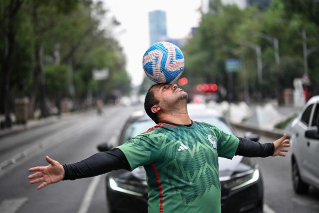 Former Mexican footballer Diego Ivan Carmona, 40, performs a freestyle routine with a ball on a traffic light in Mexico City on April 27, 2026. Mexico will co-host the biggest World Cup in history along with the United States and Canada from June 11 to July 19, 2026. (Photo by Yuri CORTEZ / AFP)