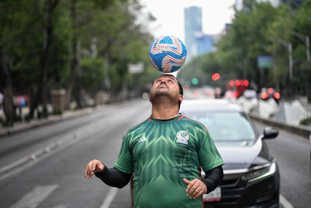 Former Mexican footballer Diego Ivan Carmona, 40, performs a freestyle routine with a ball on a traffic light in Mexico City on April 27, 2026. Mexico will co-host the biggest World Cup in history along with the United States and Canada from June 11 to July 19, 2026. (Photo by Yuri CORTEZ / AFP)