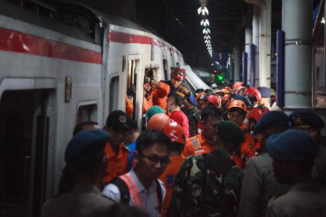 Rescuers work at the site of a train collision after a passenger train locomotive pierced through the rear car of a commuter train at Bekasi Timur station in Bekasi, West Java on April 28, 2026. (Photo by Aditya Irawan / AFP)
