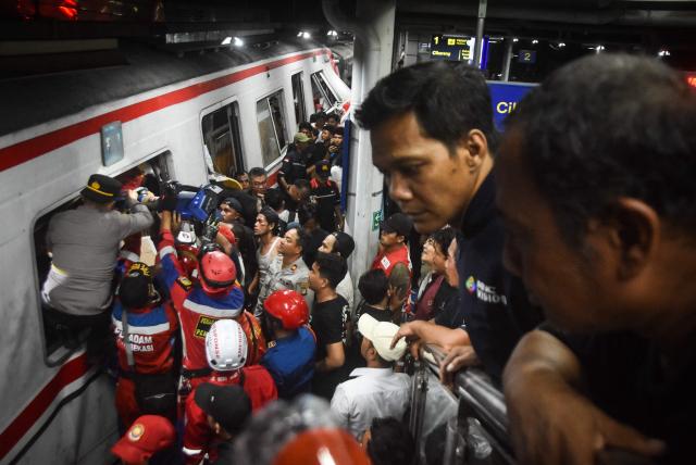 Rescuers work at the site of a train collision after a passenger train locomotive pierced through the rear car of a commuter train at Bekasi Timur station in Bekasi, West Java on April 28, 2026. (Photo by Rezas / AFP)