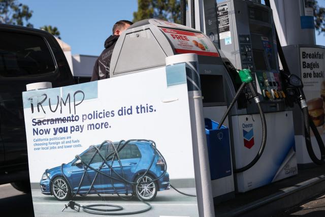 A vandalized sign about politicians, foreign oil, and gasoline taxes shows "Sacramento" crossed out and replaced with "Trump" reading, "Trump Policies Did This. Now You Pay More" is seen at a Chevron gas station in El Segundo, California, on April 27, 2026. The US Treasury Department said on April 14 that it does not plan to renew a temporary easing of sanctions on Iranian oil that aimed to ease war-related supply shocks. (Photo by Patrick T. Fallon / AFP)