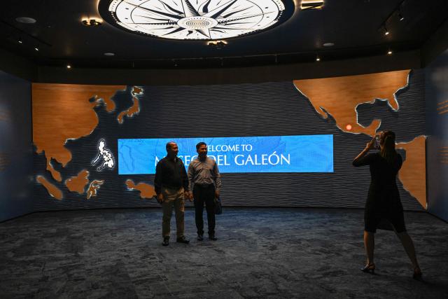 This photo taken on April 23, 2026 shows men posing for a photo at the Museo del Galeon in Manila. A full-size replica of a Spanish galleon stares out into Manila Bay, the centrepiece of a museum that will transport visitors back to the 17th century, when conscripted Philippine mariners birthed the era of globalisation. (Photo by Jam STA ROSA / AFP) / To go with AFP story Philippines-history-culture-Spain-shipping, FOCUS by Cecil MORELLA