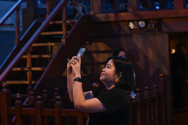 This photo taken on April 23, 2026 shows a woman visiting the Galeon Espiritu Santo, a full-scale representation of a 17th century galleon, on display at the Museo del Galeon in Manila. A full-size replica of a Spanish galleon stares out into Manila Bay, the centrepiece of a museum that will transport visitors back to the 17th century, when conscripted Philippine mariners birthed the era of globalisation. (Photo by Jam STA ROSA / AFP) / To go with AFP story Philippines-history-culture-Spain-shipping, FOCUS by Cecil MORELLA