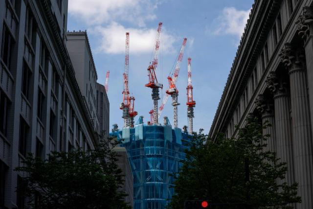 Cranes operate on the rooftop of a building under construction in Tokyo on April 28, 2026. (Photo by Kazuhiro NOGI / AFP)