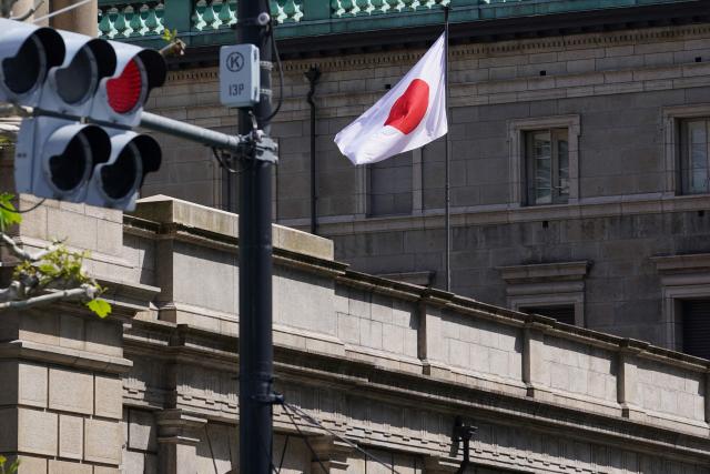 The Japanese national flag flutters in the wind on part of the Bank of Japan (BoJ) headquarters in Tokyo on April 28, 2026. (Photo by Kazuhiro NOGI / AFP)