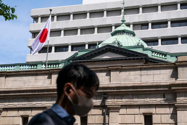 The Japanese national flag flutters in the wind on part of the Bank of Japan (BoJ) headquarters in Tokyo on April 28, 2026. (Photo by Kazuhiro NOGI / AFP)
