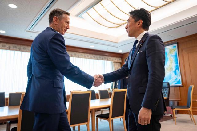 Japan’s Defence Minister Shinjiro Koizumi (R) and Commander of the US Pacific Air Forces (PACAF) Gen. Kevin Schneider shake hands at the start of their meeting at the Defence Ministry in Tokyo on April 28, 2026. (Photo by Yuichi YAMAZAKI / AFP)