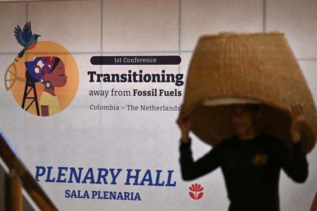 A worker carries a chair at the Estelar Convention Center during preparations ahead of the International Conference on the Just Transition Away from Fossil Fuels in Santa Marta, Colombia, on April 27, 2026. (Photo by Raul ARBOLEDA / AFP)