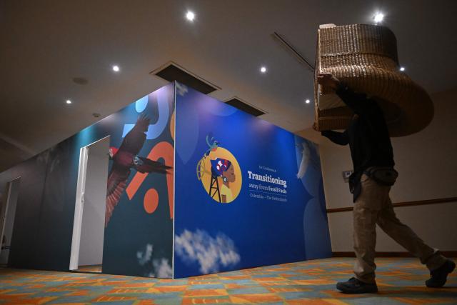 A worker carries a chair at the Estelar Convention Center during preparations ahead of the International Conference on the Just Transition Away from Fossil Fuels in Santa Marta, Colombia, on April 27, 2026. (Photo by Raul ARBOLEDA / AFP)