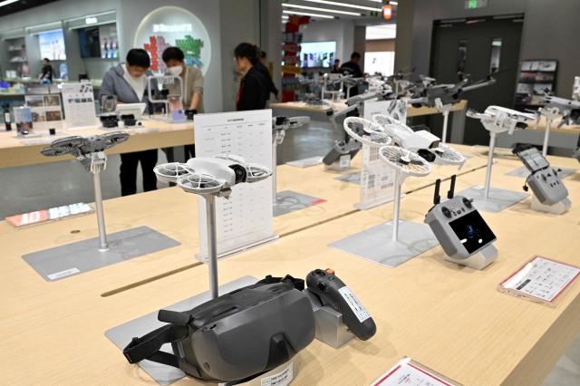 People visit a DJI store (Da-Jiang Innovators) at a mall in Beijing on April 28, 2026. On May 1, 2026 Beijing government will ban new consumer drone sales. (Photo by Adek BERRY / AFP)